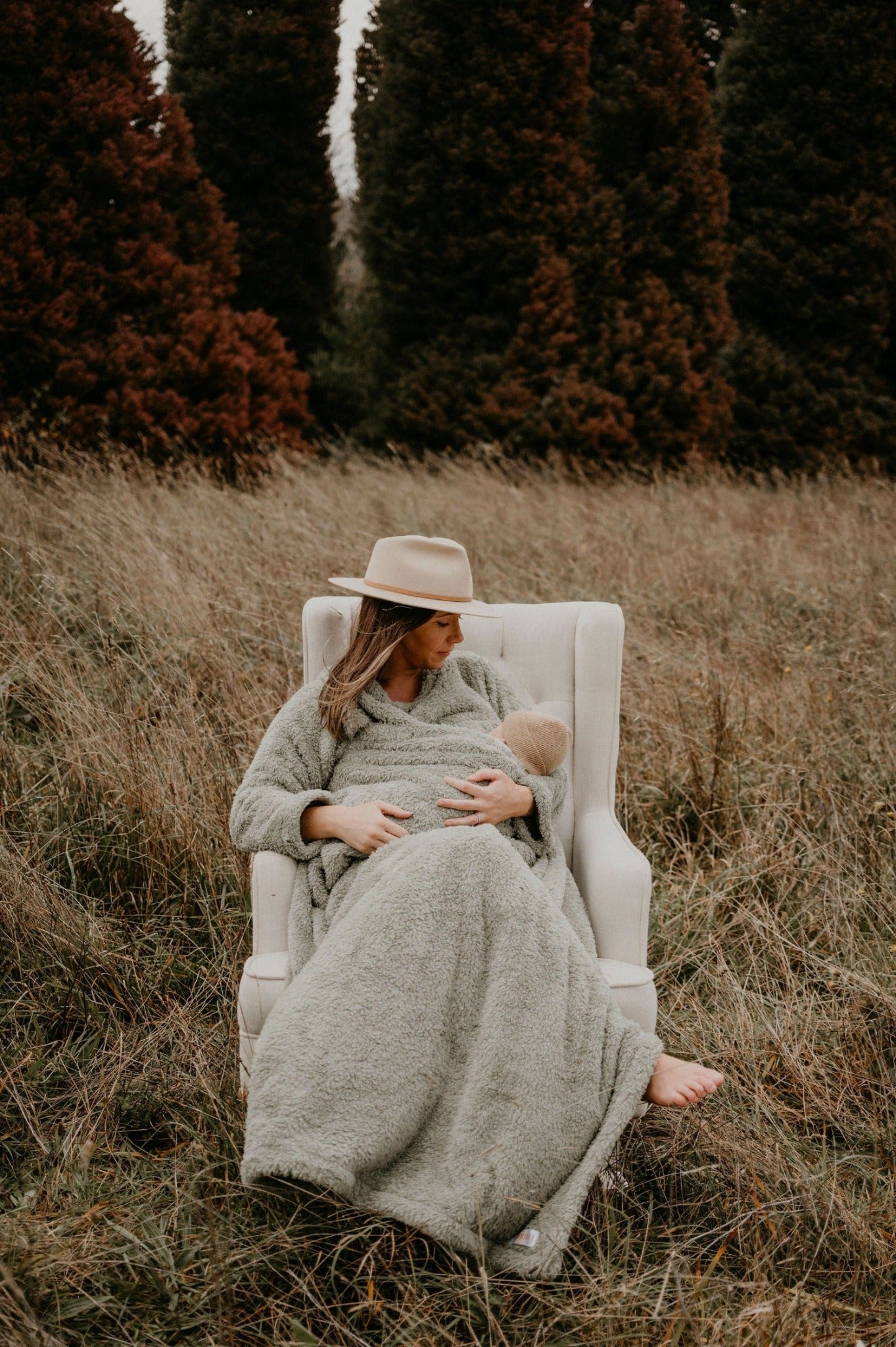 Mother breastfeeding her baby wearing a breastfeeding blanket