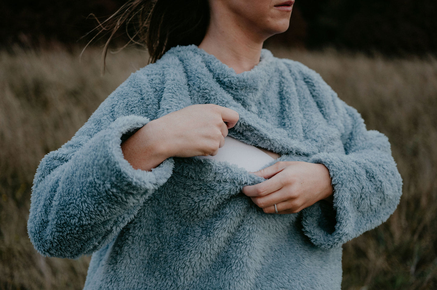 Mother opening the magnetic front of a blue breastfeeding blanket