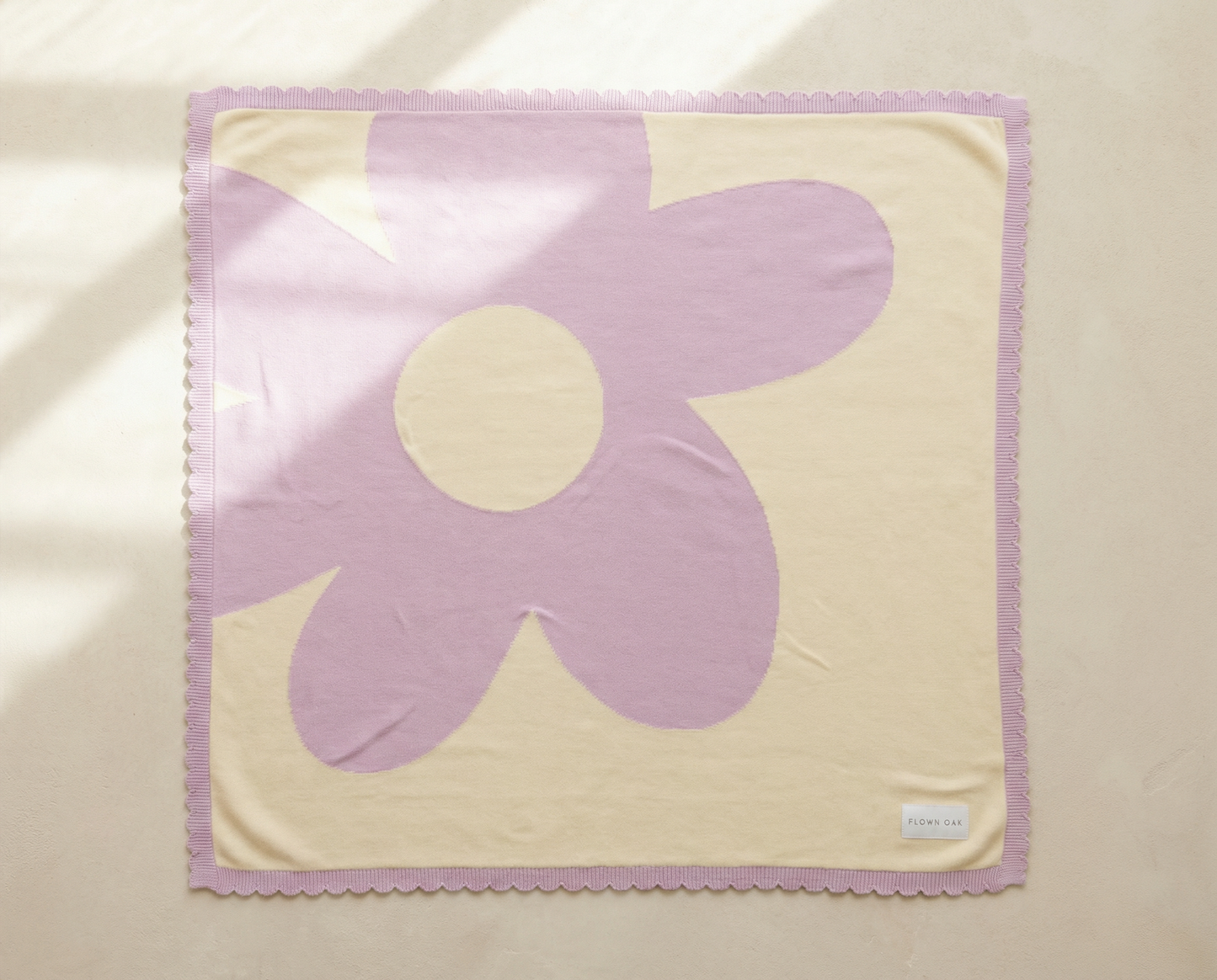 Floral-patterned fabric square with a purple flower on a beige background