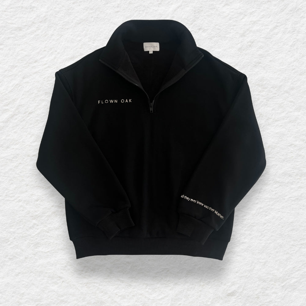 Black jumper with 'FLOWN OAK' branding on a textured white background