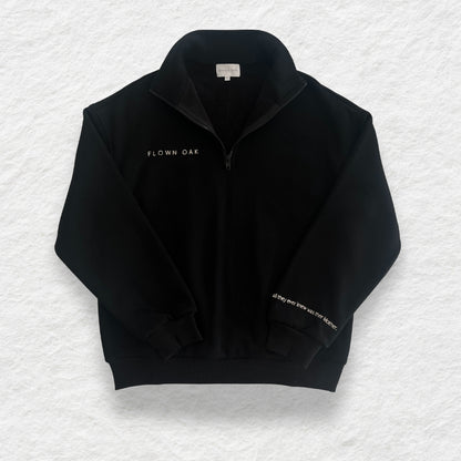 Black jumper with 'FLOWN OAK' branding on a textured white background