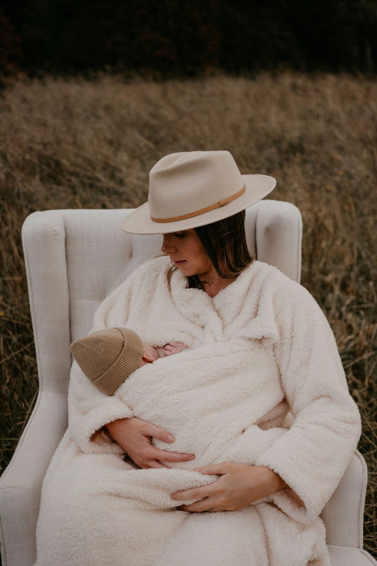 Mother breastfeeding her baby wearing a breastfeeding blanket