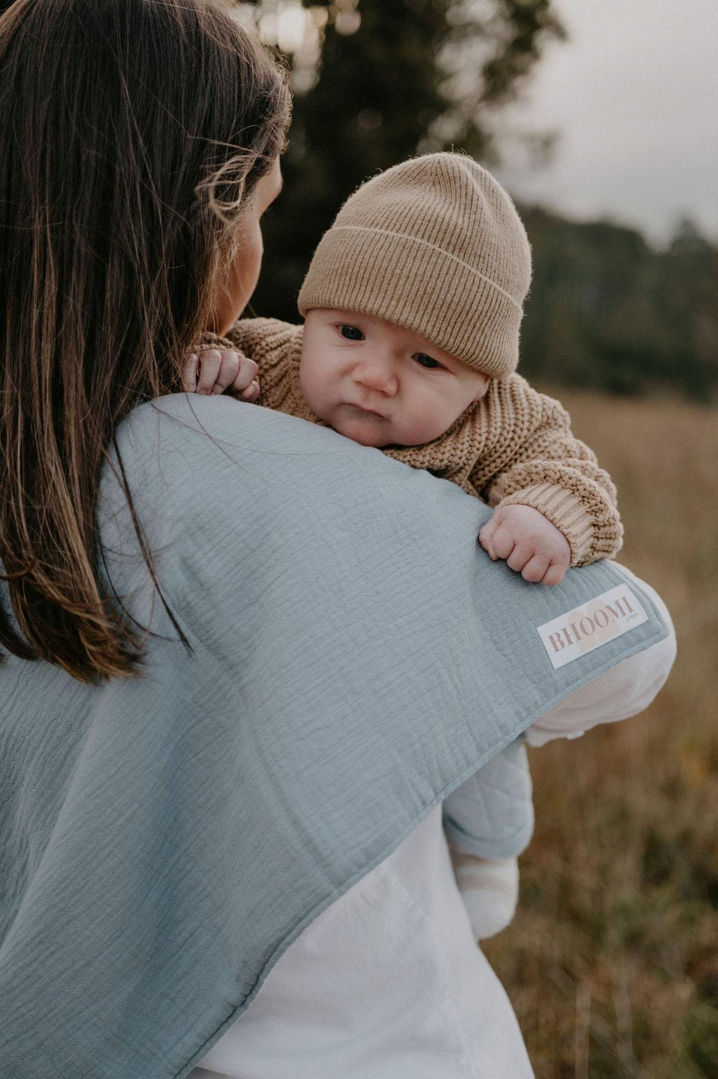 New Mum burping her baby using a tie up burp cloth