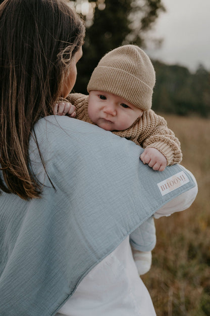 New Mum burping her baby using a tie up burp cloth