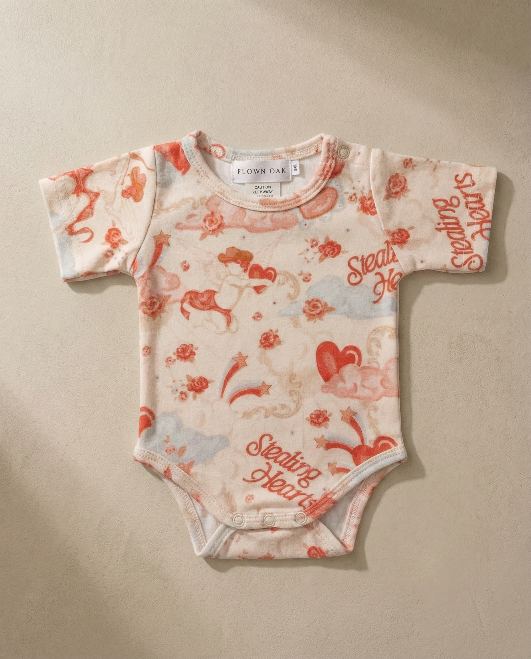 Baby onesie with red and white pattern on a beige background