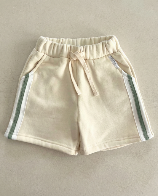 Beige shorts with green stripes on a beige background