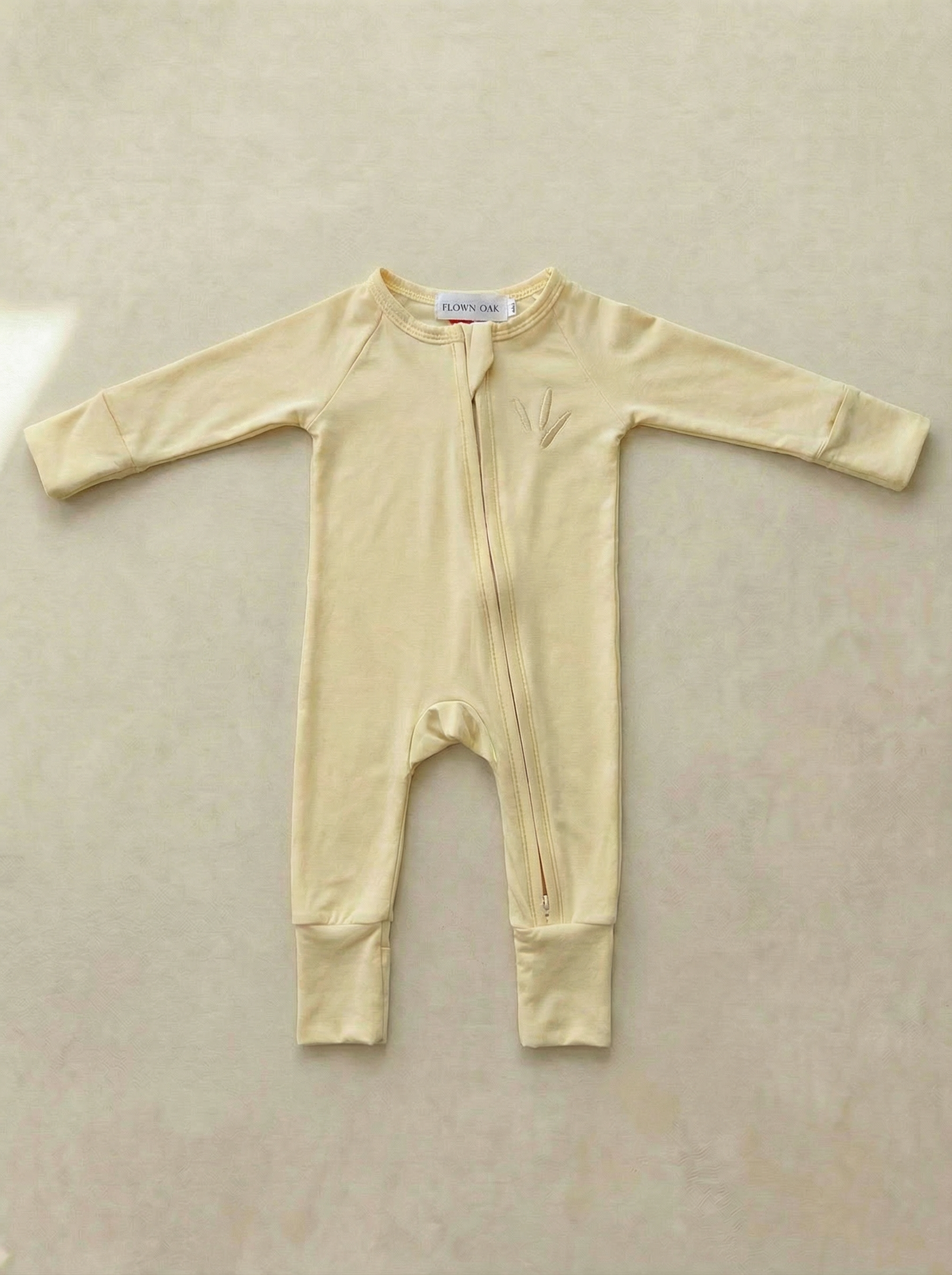 Yellow baby onesie on a light gray background