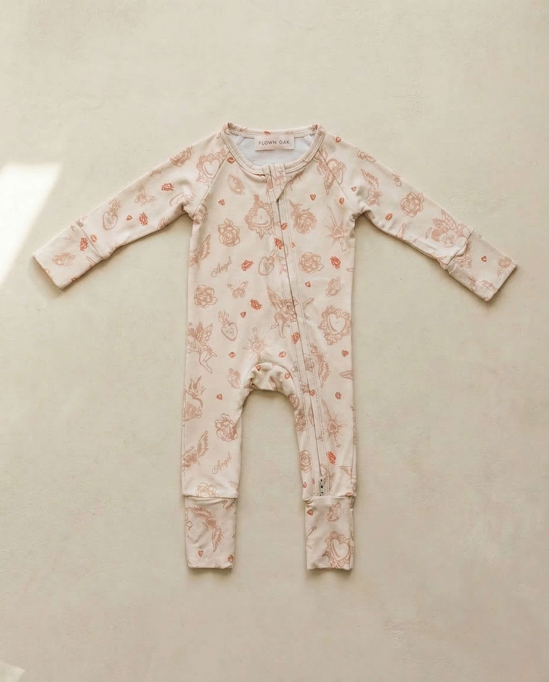 Floral-patterned baby onesie on a beige surface