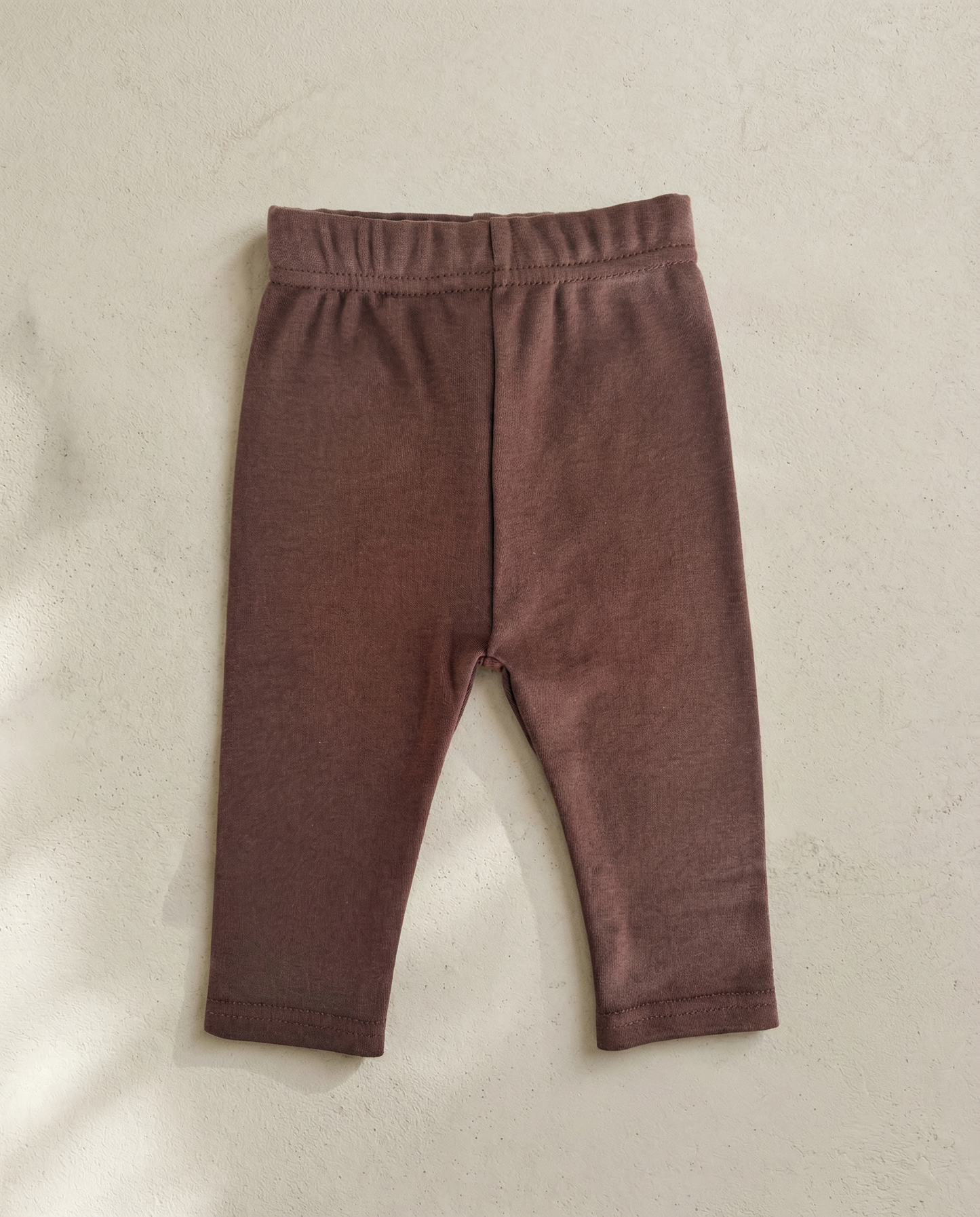 Brown baby leggings on a beige background