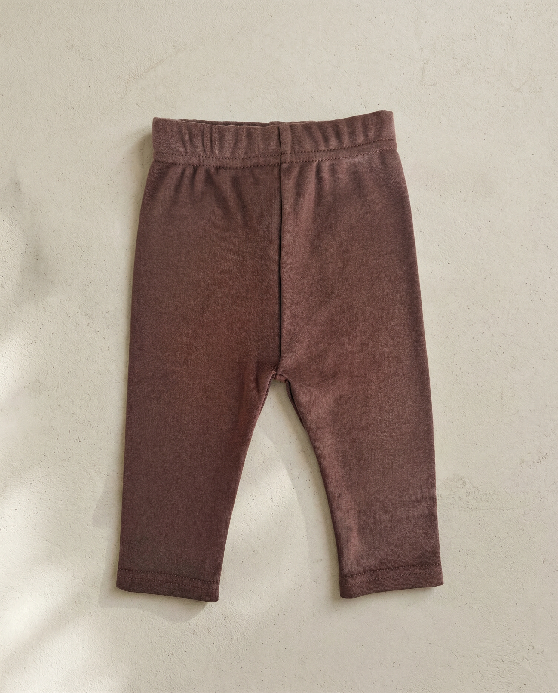 Brown baby leggings on a beige background