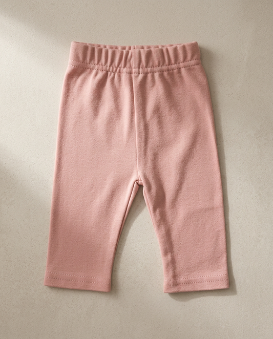 Pink baby leggings on a beige background