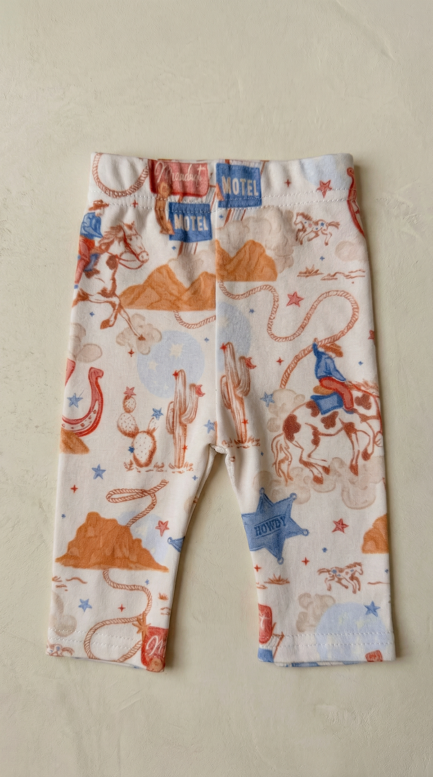 Children's leggings with cowboy print on a beige background
