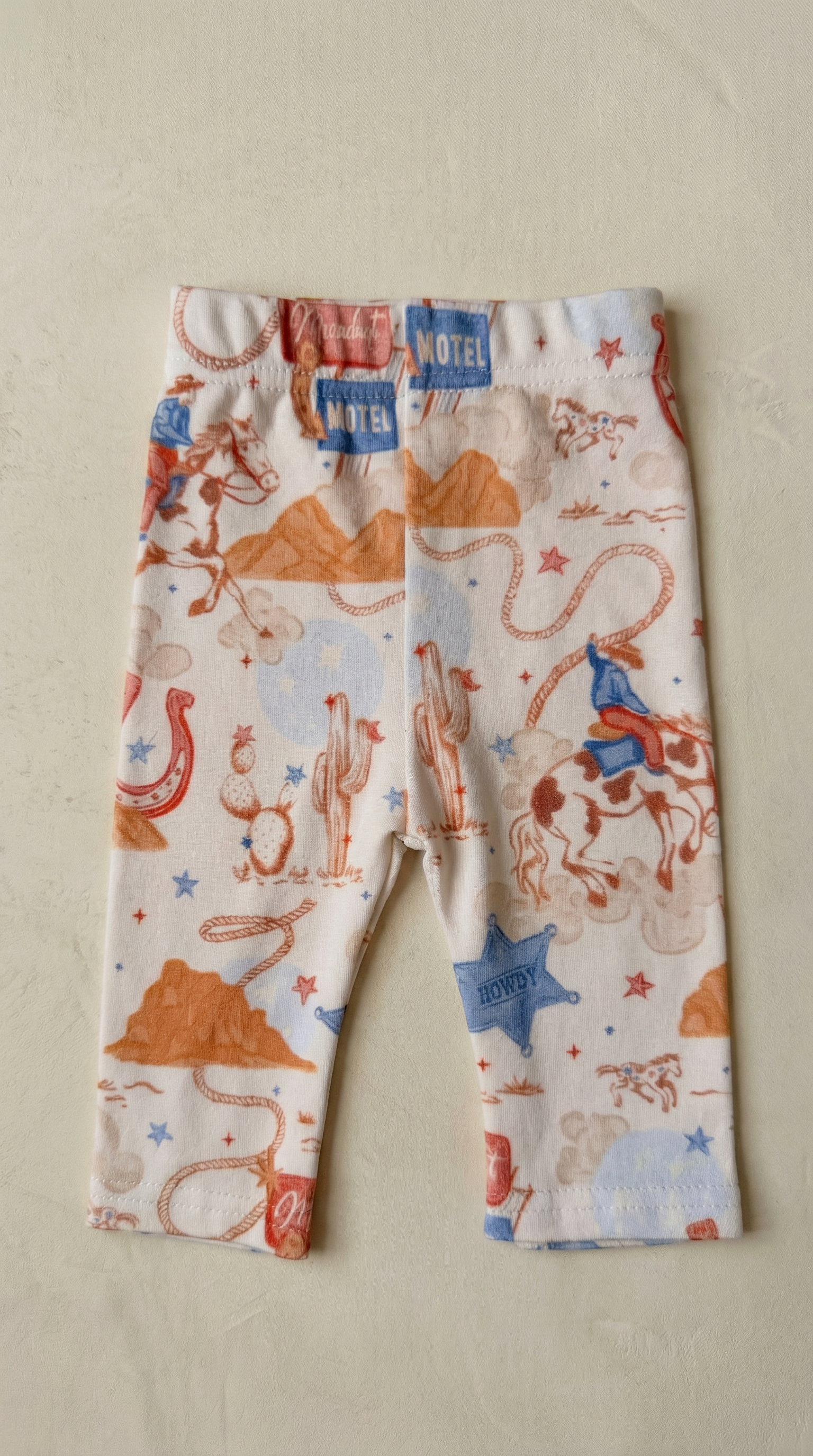 Children's leggings with cowboy print on a beige background