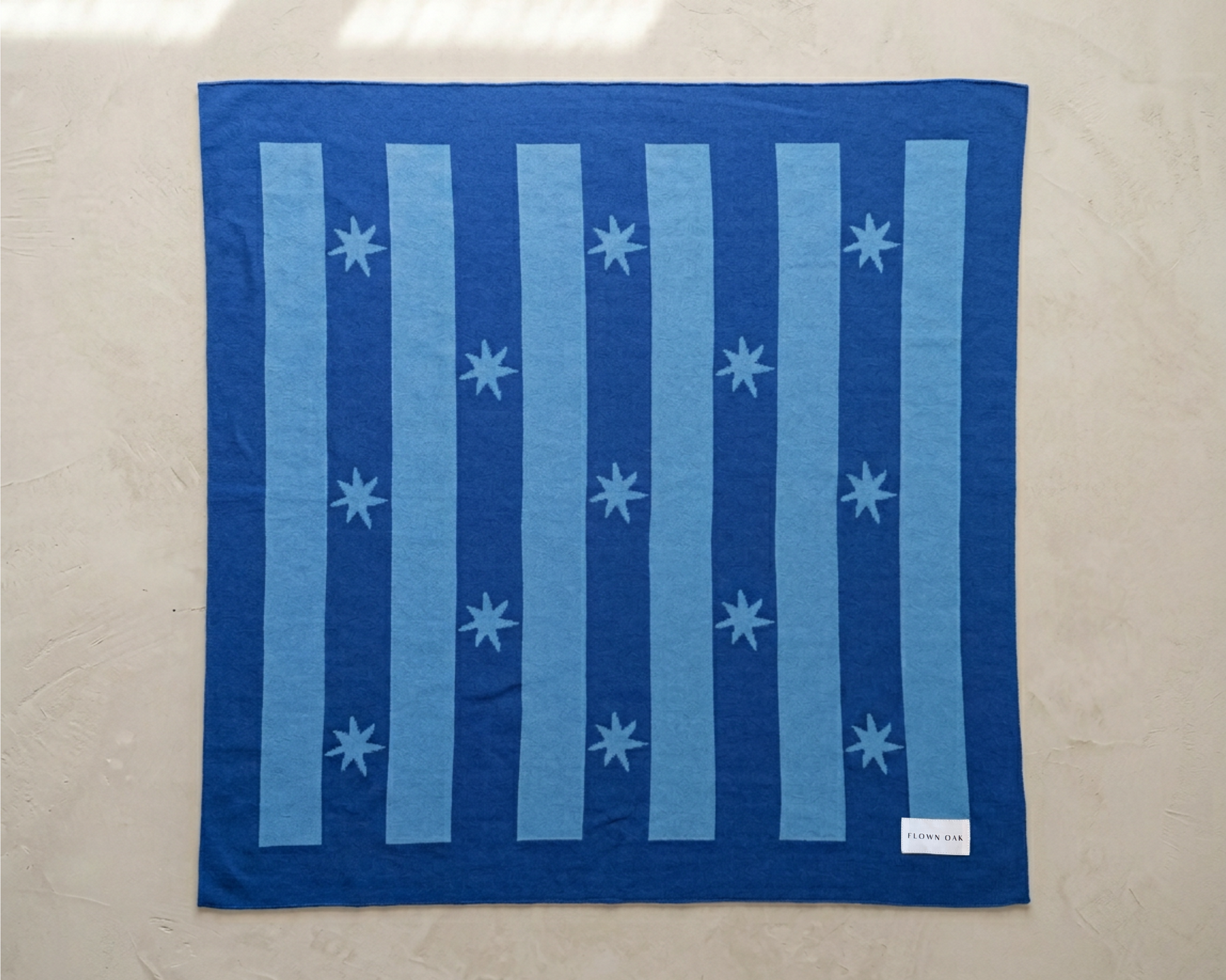 Blue baby blanket with star pattern on a beige background