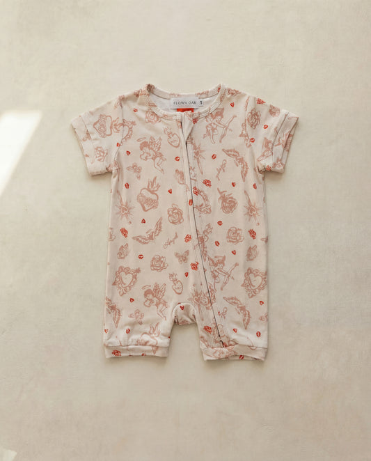 Baby romper with love prints on a beige surface