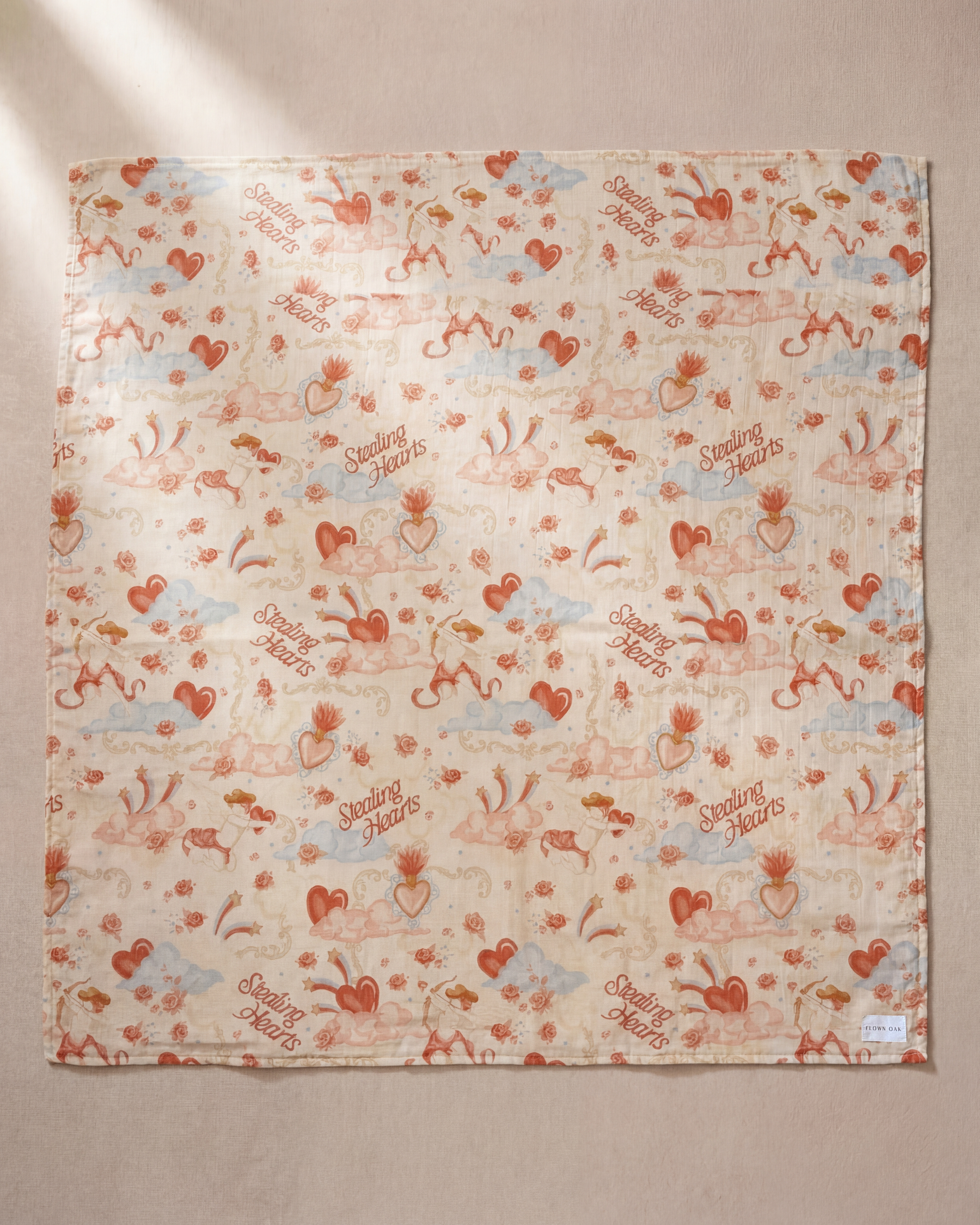 Patterned fabric with hearts and text on a beige background