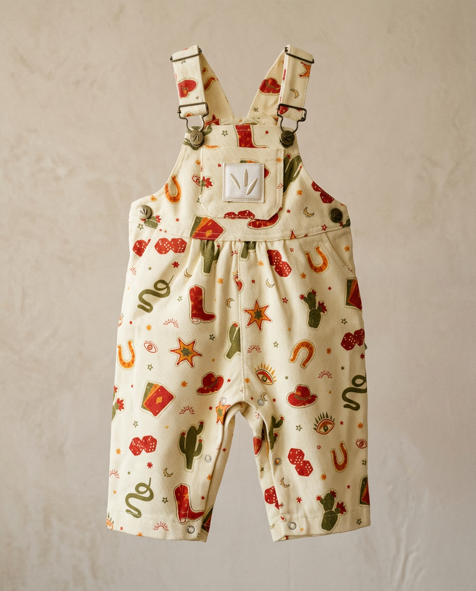 Children's overalls with cowboy-themed pattern on a beige background
