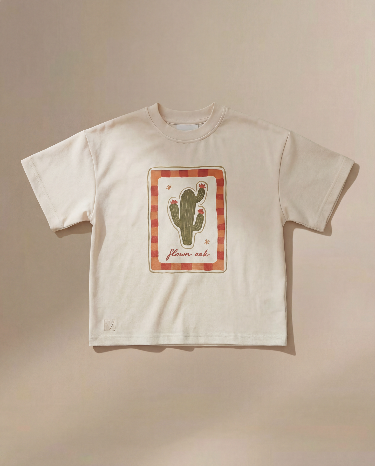Beige t-shirt with a cactus graphic on a beige background